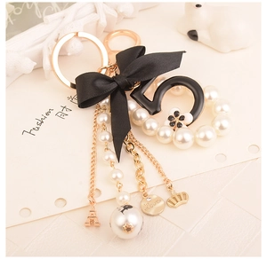 Detail of luxury pearl keychain with black bow number 5 and Eiffel Tower charms