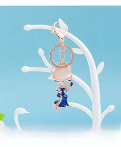 Detailed view of fox keychain with pink opal head and blue enamel floral gown decor
