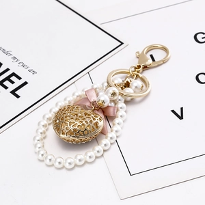 Elegant heart keychain with pearls, pink ribbon bow and golden镂空 charm for bags