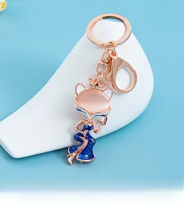 Detail of fox keychain with pink cat eye stone and blue enamel gown decoration