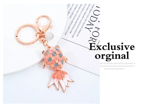 Detail of goldfish keychain with cat-eye stone inlay and rose gold enamel fish pendant