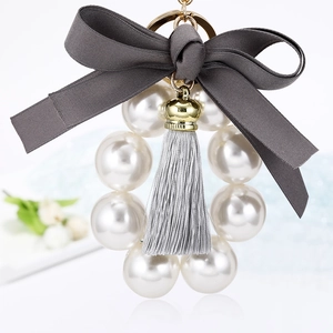 Porte-clés élégant en perles avec nœud en ruban gris et pompon pour décor de sac