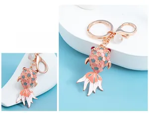 Detail of rose gold goldfish keychain with pink cat eye stones and enamel fins