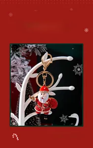 Detail of Santa Claus keychain with red rhinestones and gold plating on a jewelry tree