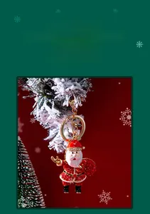 Detail of Santa Claus keychain with red rhinestones and gold lobster clasp on tree