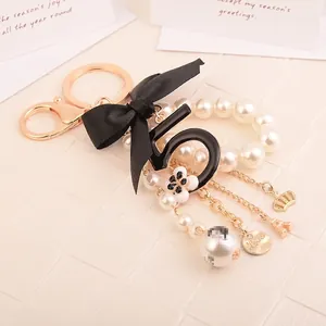 Elegant number 5 pearl keychain with black bow and Eiffel Tower charm on leather