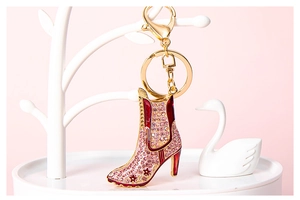 Detail of high heel boot keychain with pink rhinestones on a decorative stand
