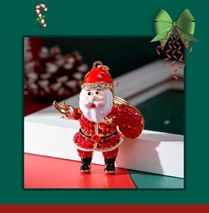 Detail of Santa Claus keychain with red rhinestones on a festive Christmas background