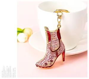 Close-up of golden stiletto boot keychain with pink rhinestones and red enamel coating