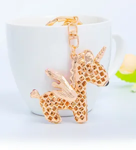 Detail view of rose gold unicorn keychain with hollow clover pattern on a white mug