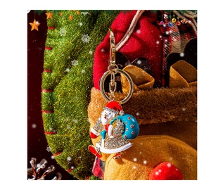 Dettaglio del portachiavi Babbo Natale con smalto colorato, strass bianchi e chiusura a scatto