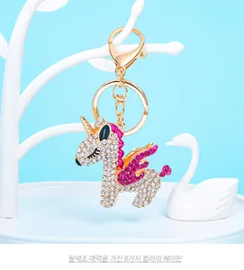 Detail of a sparkling unicorn keychain featuring white and rose purple rhinestones