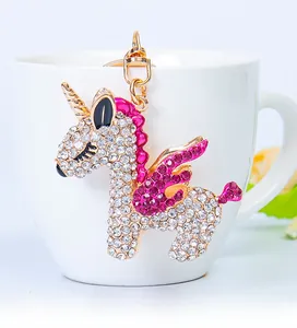 Macro detail of a sparkling gold unicorn keychain adorned with pink and white rhinestones