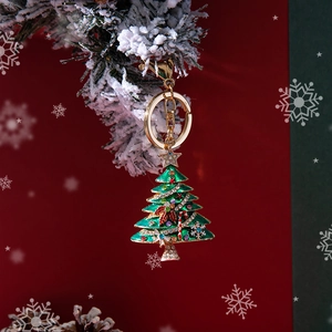 Portachiavi albero di Natale in smalto verde con strass su un ramo di pino innevato