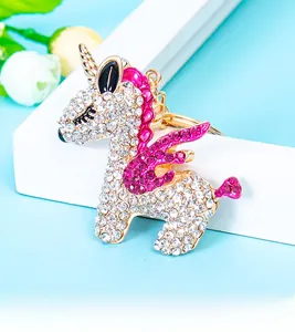 Detailed view of a gold unicorn keychain with sparkling white and rose pink rhinestones