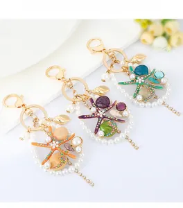 Detailed close-up of starfish and shell keychains with rhinestones and pearls
