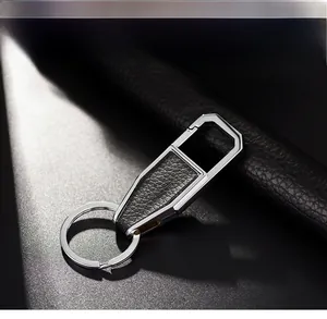 Detail of silver metal car keychain with black litchi leather texture and spring hook