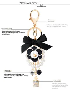 Close-up of elegant camellia charm with ribbon bow and pearl bead keychain details