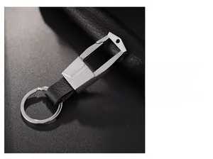 Detail showing the brushed silver metal texture and black leather strap of the keychain
