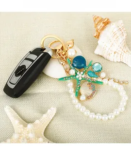 Detail of starfish keychain with blue shells and white pearls on car key fob