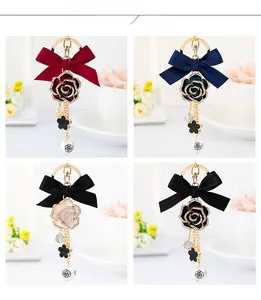 Detail view showing four color variants of camellia bowknot keychains with pearls