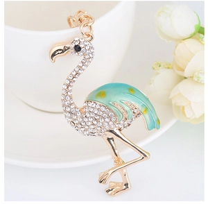 Détail du porte-clés flamant rose avec strass brillants et incrustation d'émail vert