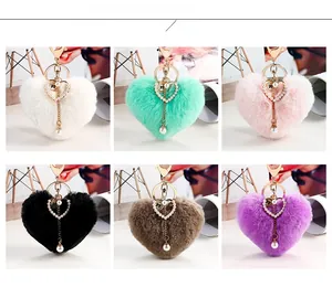 Color display of heart-shaped faux fur keychains with pearls and golden accessories