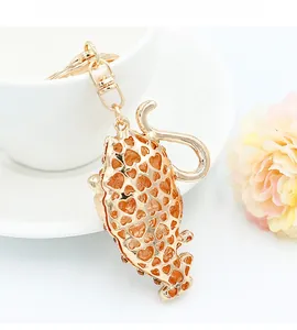 Close-up of golden cat keychain with heart-shaped cutout and sparkling rhinestones