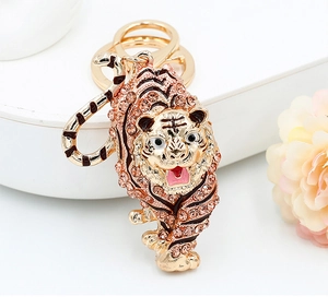 Detailed macro view of gold-plated tiger keychain with sparkling champagne rhinestones