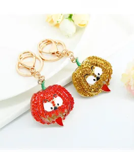 Close-up of sparkling rhinestone pumpkin keychains with funny faces on a white plate