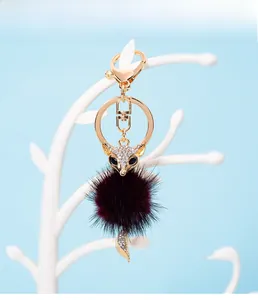 Macro shot of fox keychain featuring a wine red fur pompom and sparkling crystal details