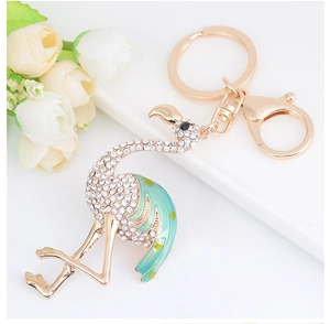 Détail d'un porte-clés flamant rose doré avec strass et finition en émail vert clair