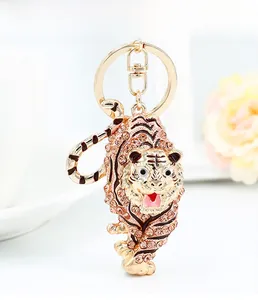 Close-up of sparkling rhinestone tiger keychain with golden lobster clasp on desk