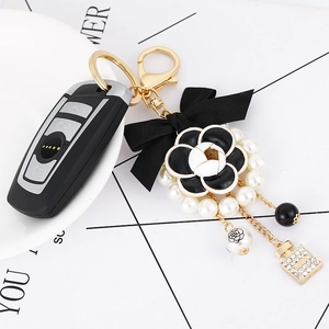 Elegant camellia bow keychain with pearls and gold charms for luxury handbags