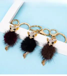 Close-up of luxury fox keychains with crystal rhinestone head and soft fur pom poms