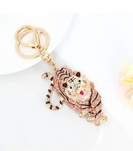 Close-up of golden zodiac tiger keychain with pink rhinestones and enamel details