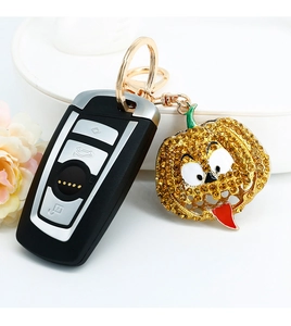 Macro detail of Halloween pumpkin keychain with yellow rhinestones and golden ring