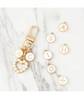 Close-up of DIY alphabet letter keychain with gold lobster clasp and pearl heart pendant