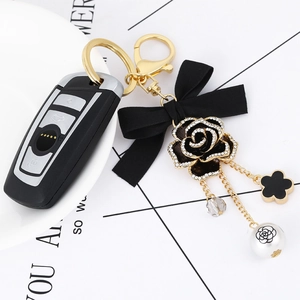 Elegant gold flower keychain with black ribbon bow and pearl charms for car keys