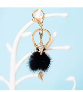 Close-up of black mink fur fox keychain with sparkling crystals and golden metal clasp