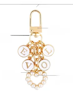 Detail of gold-tone alloy keychain with LOVE lettering disks and pearl heart charm
