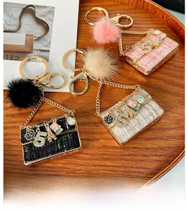 Detail of tweed fabric mini bag keychains with gold metal hardware and faux fur charms