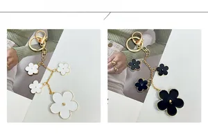Detail showing black and white enamel flower keychains on golden alloy chains