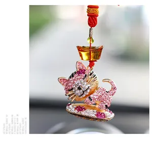 Détail d'un porte-clés chat en cristal rose orné de strass et d'un cordon tressé