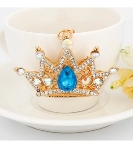 Detailed macro view of a crystal crown keychain with a pear-shaped blue diamond and rhinestones