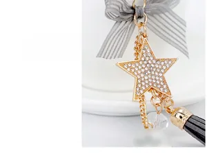 Detail view of a sparkling rhinestone star keychain with grey silk bow and tassel charms
