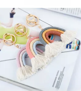 Macro detail of handmade macrame rainbow keychains with cotton tassels and gold clips