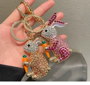Detailed close-up of two rabbit keychains featuring sparkling rhinestones and carrots