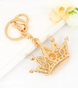 Detail of a golden crown keychain with lobster clasp and round ring on white background