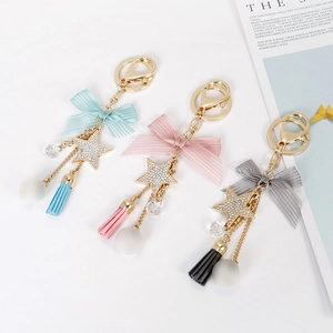 Star tassel keychain with bow and faux fur pompom charms for bags in blue and pink
